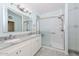 Bright bathroom showcasing double sinks, a mirrored cabinet, and a glass-enclosed shower at 11580 N 86Th Ln, Peoria, AZ 85345