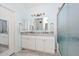 This well-lit bathroom has a double vanity, large mirror, and frosted glass shower at 11580 N 86Th Ln, Peoria, AZ 85345