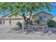 Charming single-story home with a well-manicured front yard featuring desert landscaping and mature trees at 11580 N 86Th Ln, Peoria, AZ 85345