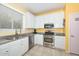 Modern kitchen with stainless steel appliances, sleek countertops, white cabinets, and a sink with large window at 11580 N 86Th Ln, Peoria, AZ 85345