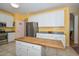 Well-lit kitchen featuring an island with a wood countertop, stainless steel appliances and white cabinetry at 11580 N 86Th Ln, Peoria, AZ 85345