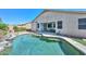 Backyard pool featuring stone waterfall, patio, and mature desert landscaping at 11580 N 86Th Ln, Peoria, AZ 85345