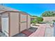 Backyard shed offers extra storage space, complemented by a neat brick pathway and well-maintained lawn at 11580 N 86Th Ln, Peoria, AZ 85345