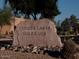 Rock sign for Coyote Lakes Golf Club at entry with desert plants and blue sky at 11631 W Lemon Ct, Surprise, AZ 85378
