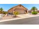 Side view of a tan home featuring a two-car garage and desert landscaping at 11631 W Lemon Ct, Surprise, AZ 85378