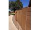 View of the backyard gate, with a wall, rock bed and sidewalk leading to the grass at 1350 S Greenfield Rd # 1221, Mesa, AZ 85206