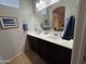 Bathroom with double sink vanity, framed mirror, and blue towel accents at 1350 S Greenfield Rd # 1221, Mesa, AZ 85206