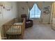 Bedroom with a crib, recliner, and calming decor at 1350 S Greenfield Rd # 1221, Mesa, AZ 85206