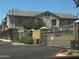 Exterior of a building showcasing clean landscaping, a grey stucco facade and a large automatic gate at 1350 S Greenfield Rd # 1221, Mesa, AZ 85206