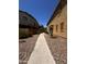 Exterior walkway alongside a property, featuring rock landscaping between homes at 1350 S Greenfield Rd # 1221, Mesa, AZ 85206