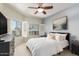 Cozy bedroom with a ceiling fan, carpet flooring, and large windows with blinds at 14000 N 94Th St # 2187, Scottsdale, AZ 85260