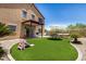 Spacious backyard with artificial grass, patio, umbrella-covered table, hammock, and playset, ideal for Gathering fun and entertaining at 15006 N 172Nd Ln, Surprise, AZ 85388