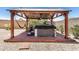 Backyard patio features a wood gazebo and a hot tub, perfect for outdoor relaxation and entertaining at 15006 N 172Nd Ln, Surprise, AZ 85388