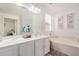 Bright bathroom featuring a dual vanity, bathtub, and neutral color palette at 15006 N 172Nd Ln, Surprise, AZ 85388