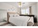 Bright bedroom with a tufted headboard, large mirror, ceiling fan, and plenty of natural light from the window at 15006 N 172Nd Ln, Surprise, AZ 85388