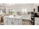 Bright, open kitchen with white cabinetry, stainless steel appliances, and modern island at 15006 N 172Nd Ln, Surprise, AZ 85388