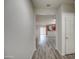 Inviting hallway with modern wood-look flooring that leads to open-concept living space at 20410 N Mac Neil St, Maricopa, AZ 85138