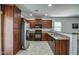 Fully equipped kitchen featuring stainless steel appliances, granite countertops, and dark wood cabinets at 20410 N Mac Neil St, Maricopa, AZ 85138
