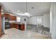 Open kitchen boasts stainless steel appliances, granite counters, and blends seamlessly into the living area with wood-look floors at 20410 N Mac Neil St, Maricopa, AZ 85138