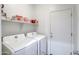 Clean laundry room with side by side washer and dryer and a storage shelf at 20410 N Mac Neil St, Maricopa, AZ 85138