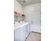 Functional laundry room with modern washer and dryer, shelving, and convenient access to the exterior at 20410 N Mac Neil St, Maricopa, AZ 85138