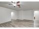 Bright living room features modern floors, a ceiling fan, and neutral wall paint at 20410 N Mac Neil St, Maricopa, AZ 85138
