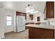 Spacious kitchen featuring white appliances, wood cabinets, and door to the outside at 2650 W Union Hills Dr # 215, Phoenix, AZ 85027