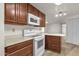 Bright kitchen featuring white appliances, wood cabinets, and modern lighting at 2650 W Union Hills Dr # 215, Phoenix, AZ 85027
