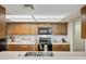 Kitchen features wood cabinets, light countertops, black appliances, and overhead lighting at 2929 E Broadway Rd # 50, Mesa, AZ 85204