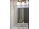 Close up of a bathroom mirror with a silver frame, vanity, and sink at 3325 S Shafer Dr, Tempe, AZ 85282