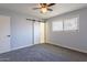 Cozy bedroom with carpet, a window with blinds, and a unique sliding barn door at 3325 S Shafer Dr, Tempe, AZ 85282