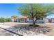 Single-story home with gravel front yard, shaded by a mature tree, and a carport at 3325 S Shafer Dr, Tempe, AZ 85282