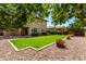 Lush backyard with manicured lawn, rock landscaping, and mature trees seen from the side at 3338 E Coconino Dr, Gilbert, AZ 85298