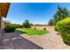 A well maintained backyard features a manicured lawn surrounded by decorative rock and lush landscaping at 3338 E Coconino Dr, Gilbert, AZ 85298