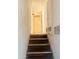 Stairway leading to the upper level with built-in storage, carpeted steps, and white walls at 4316 W Rose Ln, Glendale, AZ 85301