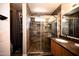 Bathroom showcasing a glass shower stall with tile surround and wood laminate floors at 4527 E Amberwood Dr, Phoenix, AZ 85048