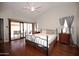Spacious main bedroom features wood floors, ceiling fan, and sliding glass door to patio at 4527 E Amberwood Dr, Phoenix, AZ 85048
