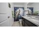 Bathroom with stylish peacock shower curtain, vanity with granite countertop, and updated fixtures and wall decor at 5267 E Diatomite Dr, San Tan Valley, AZ 85143