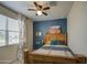 Charming bedroom features a rustic wood bed frame and a cool-toned accent wall with southwest-themed artwork at 5267 E Diatomite Dr, San Tan Valley, AZ 85143