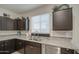 Close up of a kitchen sink featuring granite countertops, stainless steel appliances and modern cabinets at 5267 E Diatomite Dr, San Tan Valley, AZ 85143