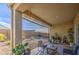 Covered patio with comfortable seating overlooks a low-maintenance gravel backyard, perfect for relaxing outdoors at 5267 E Diatomite Dr, San Tan Valley, AZ 85143