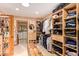 Walk-in closet with custom shelving, hanging racks, and a central wood bench offering ample storage and organization at 6330 E Delcoa Ave, Scottsdale, AZ 85254