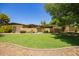 Lovely home with a lush green lawn, decorative gate, and desert landscaping at 6330 E Delcoa Ave, Scottsdale, AZ 85254