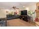 Cozy living area with a leather sofa, entertainment center, ceiling fan, and unique stone accent wall at 6330 E Delcoa Ave, Scottsdale, AZ 85254