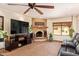Inviting living room featuring a stone fireplace, large TV, and comfortable seating area at 6330 E Delcoa Ave, Scottsdale, AZ 85254