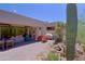 A back patio featuring red brick pavers, desert landscaping, and covered dining area at 6714 E Nightingale Cir, Scottsdale, AZ 85266