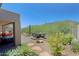 A backyard patio with desert landscaping, built in grill, and fire pit at 6714 E Nightingale Cir, Scottsdale, AZ 85266