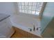 Close-up of a soaking tub with tile surround and textured glass shower wall at 6714 E Nightingale Cir, Scottsdale, AZ 85266