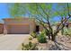 Desert home with a two-car garage and drought-resistant landscaping, including cacti and native plants at 6714 E Nightingale Cir, Scottsdale, AZ 85266