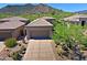 Desert home with a two-car garage and drought-resistant landscaping, including cacti and native plants at 6714 E Nightingale Cir, Scottsdale, AZ 85266